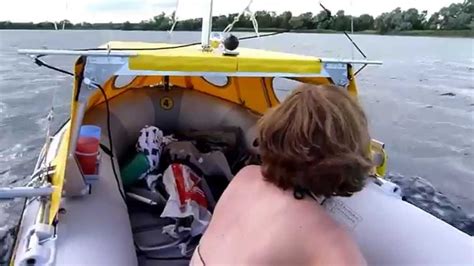 Photo about a small inflatable boat with a cabin and an outboard motor on a tributary of the volga river. Intex Mariner with sail and cabin diy homemade inflatable ...