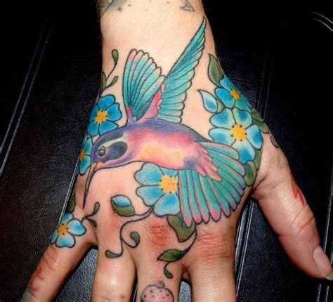 This tattoo represents a baby angel. Hand Hummingbird Tattoo by Cherub Tattoo