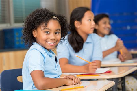 But her voice is lovely. Cute Schoolgirl Smiles At The Camera In Classroom Stock ...