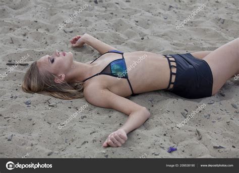 A woman beggar was shot dead in the street after approaching a stranger and asking for 18p. Scripted Crime Scene Beach Young Woman Lying Dead Beach — Stock Photo © eddiephotograph #209538190