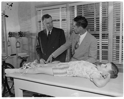 The name id tag can be engraved on both. Two men standing next to boy on examination table - The ...