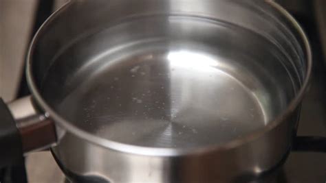 Boiling water in a paper cup on the stove. Boiling Water On Stove In Kitchen. High Speed Movie. Stock ...