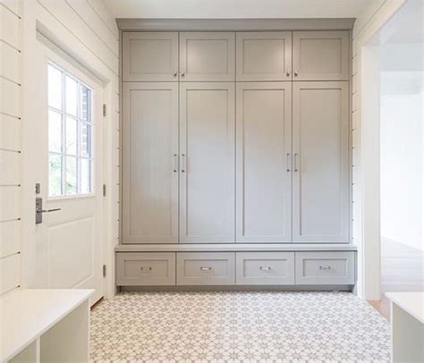 Charcoal gray laundry room features charcoal gray louvered cabinets adorned with brass handles built above stacked gray drawers adorned with vintage brass ring hardware situated next to a dry erase calendar. Floor to ceiling lockers and shiplap! | Mud room storage ...