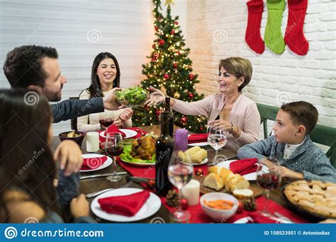 For some, it's the image of a family sitting around a big feast—a pleasant, calm scene. Family Celebrating At Dinner Party During Christmas Stock ...