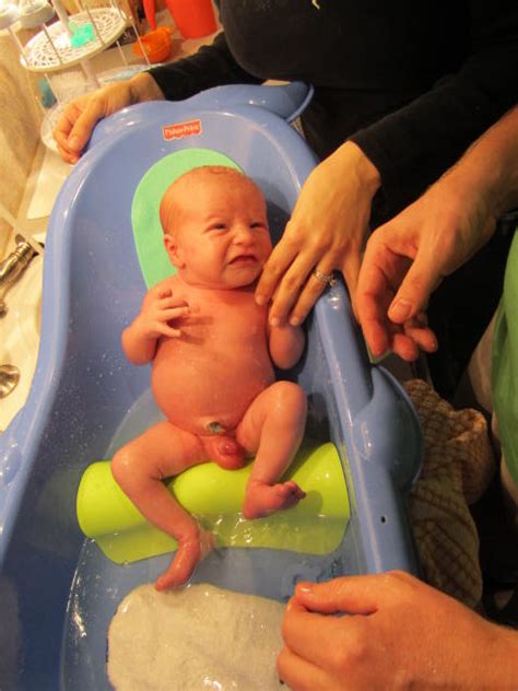 Gradually slip your baby into the tub feet first, using one hand to support her neck and head. Saltz of the Earth: Levi's First Bath at Home