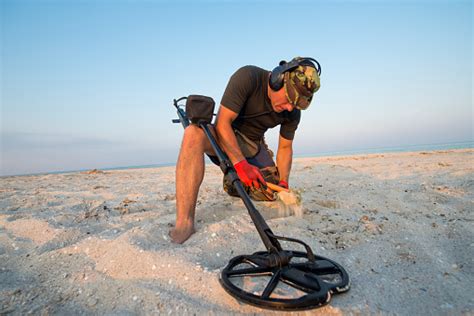 Why does beach metal detecting yield better results? Man With A Metal Detector On A Sea Sandy Beach Stock Photo ...