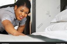 african maid making hotel bed housekeeper