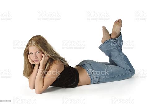 David prado / addictive creative; Blonde Teen Girl Lying On Tummy stock photo | iStock