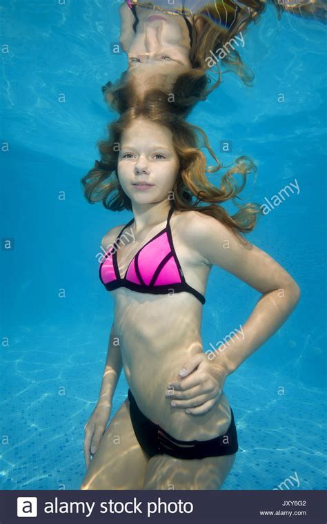 Melanie river had just turned ten years old, but she had never been to school. Beautiful teen girl posing under water in the pool Stock ...
