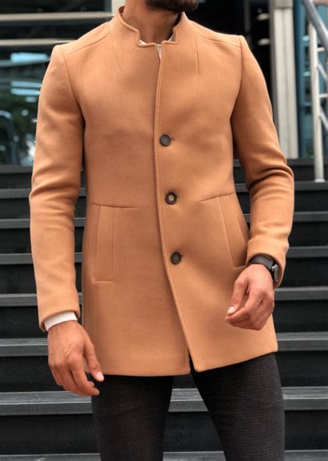 It features a crisp peak lapel and comes in a the carefully refined slim fit design slips perfectly over a jacket but sits close enough to the body to suit a simple shirt and a layered piece of knitwear. GentWith Fabros Camel Slim Fit Wool Coat - Gent With