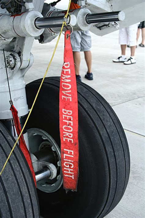 Remove before flight is a safety warning often seen on removable aircraft and spacecraft components, typically in the form of a red ribbon, to indicate that a device, such as a protective cover or a pin to prevent the movement of mechanical parts, is only used when the aircraft is on the ground (parked or taxiing). REMOVE BEFORE FLIGHT | airportzentrale.de