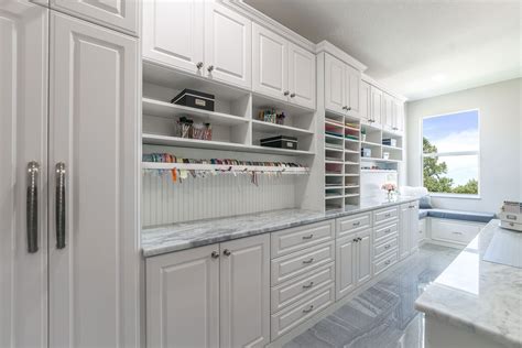 The best type of storage furniture you can use tends to be cabinetry and cubby spaces. This large crafting room features a wrapping station with ...