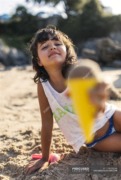 Do you think the behavior. Little girl playing with sand on the beach — One Girl Only ...