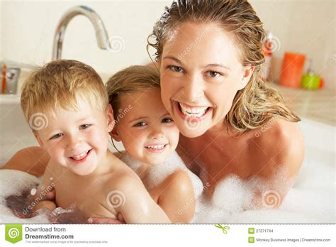 A boy is in the bathtub being bathed by a woman. Moeder Met Kinderen Die In Bad Ontspannen Stock Foto ...