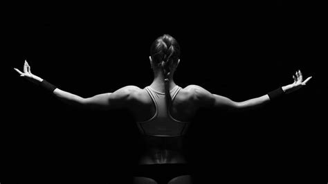 Search for cream for pain in back. Athletic young woman showing muscles of the back ...