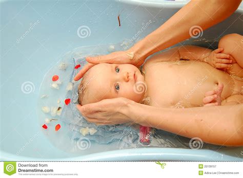 Gather the supplies you'd use for a sponge bath, a cup of rinsing water and baby shampoo, if needed, ahead of time. Baby bath stock image. Image of small, infant, petals ...