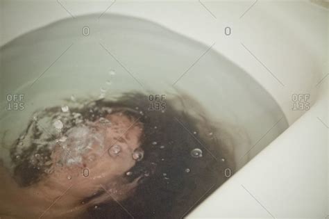 How does it do this? Woman drowning in a bathtub stock photo - OFFSET