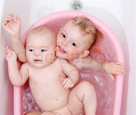 You may prefer to wash their face, neck, hands and bottom carefully instead. Beauty baby girls in bath | Stock image | Colourbox