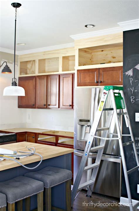 The cabinets are plumb and level but due to the ceiling slope (old, not by design) looks crooked. Building Cabinets up to the Ceiling from Thrifty Decor Chick