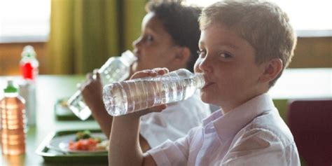 Mahasiswa Minum Air dari Botol di Kelas